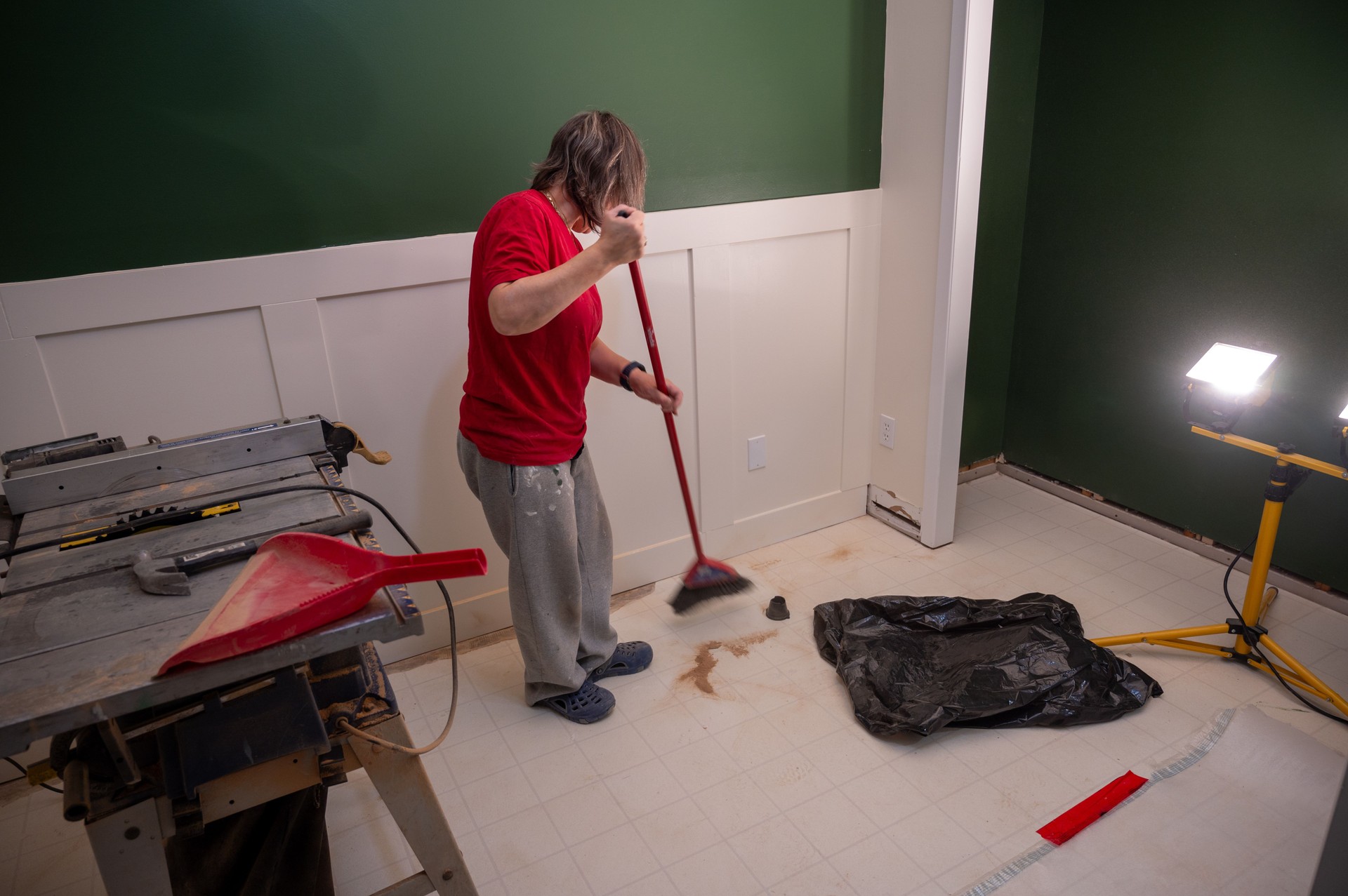 Mature woman sweeping wood dust